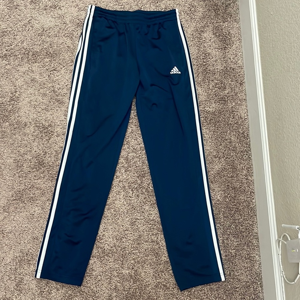 Navy blue and white Adidas track pants.